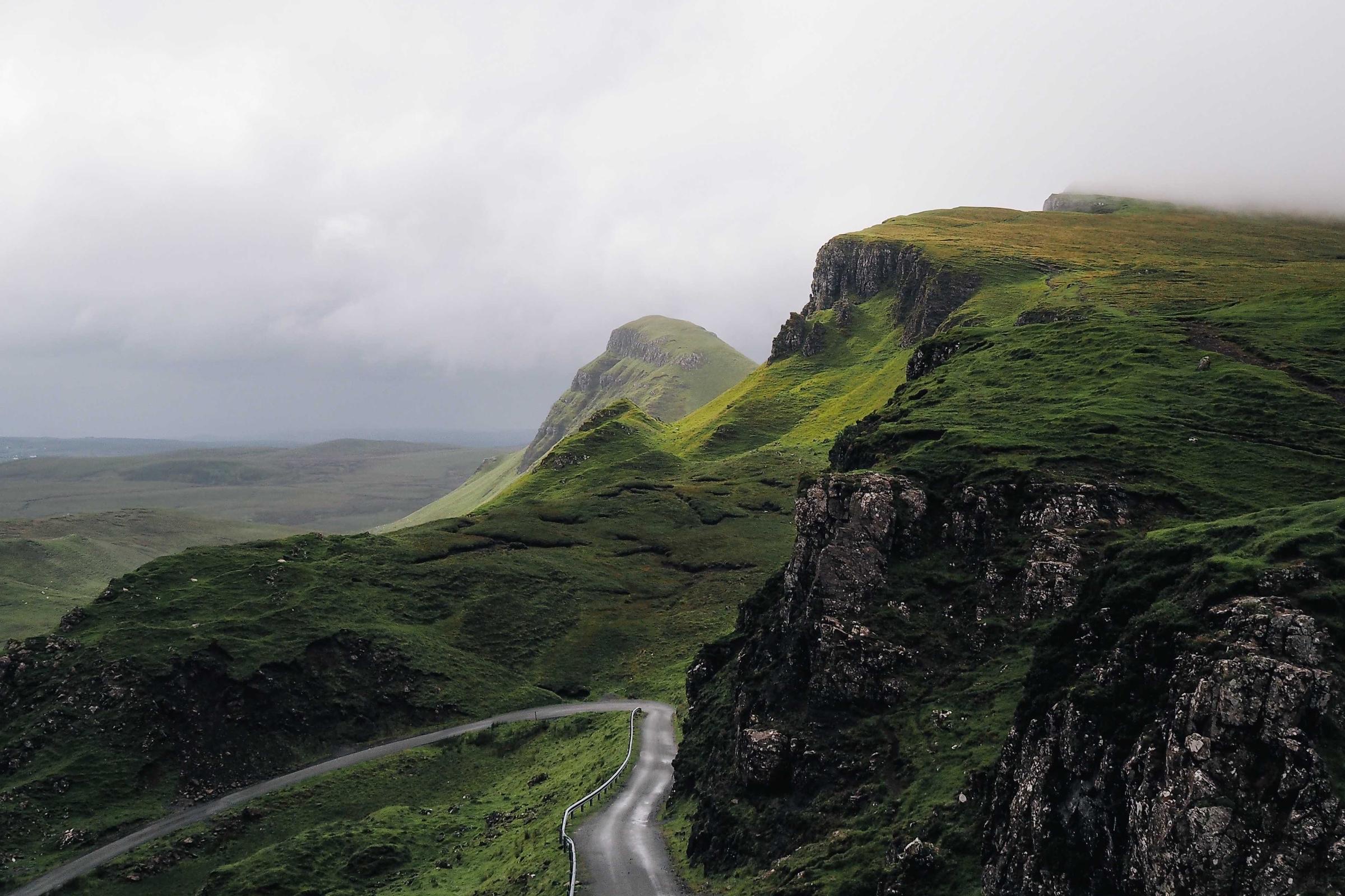 A green coastal hillside under a grey sky, an example of a photo recovered at full resolution.
